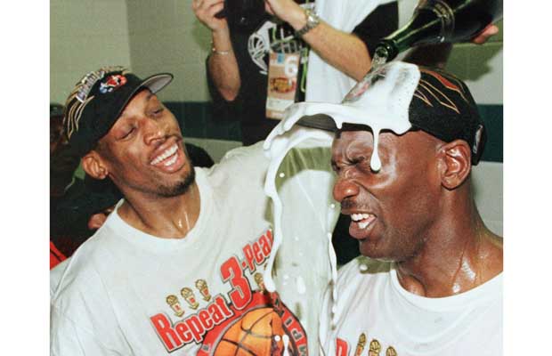 Dennis Rodman (L) of the Chicago Bulls pours champ
